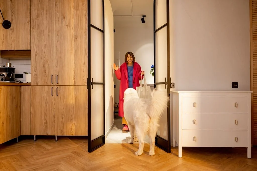 Mujer saludando a su perro al llegar a casa